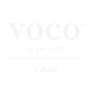 VOCO Villach Logo - weißer Schriftzug auf Transparenten Grund - darunter Text Villach