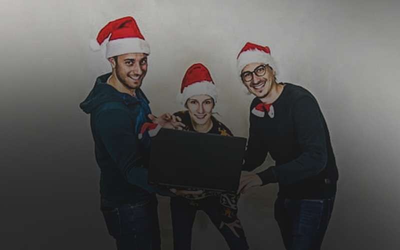 drei mitarbeiter in weihnachtsmützen beim virtueller weihnachtsfeier
